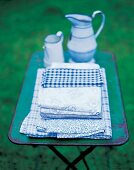 blaue Baumwolltischwäsche, kariert, mit Blütenmuster auf Tisch m. Kannen