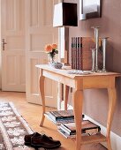 Small wooden table with books and table lamp in living room