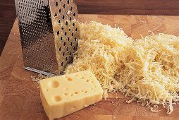 Käse wird für ein Käsefondue mit einer Reibe geraspelt. Nr.1