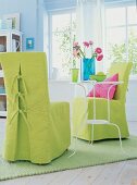 Stühle mit hellgrünen Hussen auf grünem Teppich