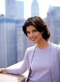 Portrait of pretty woman with short dark hair wearing purple jacket, smiling