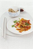 Asia-Gemüse aus dem Wok, Schale mit Reis, Sojasoße, Stäbchen