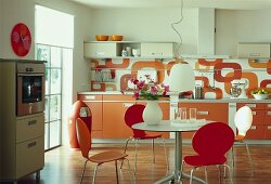 Küche in Orange und Weiß mit rundem Esstisch