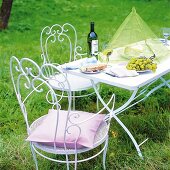 Wein, Käse, Brot +Trauben im Garten, romantische Eisenmöbel mit schnörkel