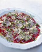 Close-up of beef carpaccio with parmesan cheese and cress on plate
