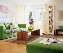 Living room with green sofa, wooden table and book shelf