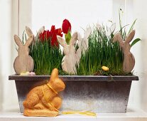 Wooden bunnies in flower box with snowdrops and tulips with dekohase