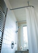 Shower room with white curtains and towel warmer