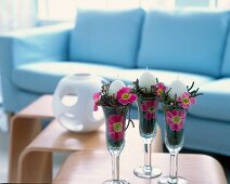 Champagne glasses filled with moss, primrose and small branches