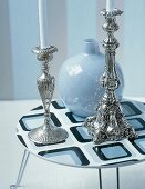 Zwei silberne Kerzenleuchter und Vase auf Lounge-Tisch