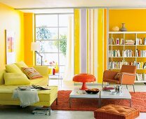 Living room with yellow walls, colourful furnishings, bookcase and sofa