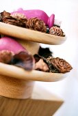 Close-up of etagere with pine cones, cedar and dried flowers