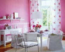 Modern style laid dining table with pink wall, chair, flower vase and curtains
