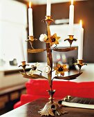 Close-up of five-armed brass candle chandelier from France with burning candles on table