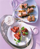 Vitello tonnato and chicken breast in skewers on serving dish