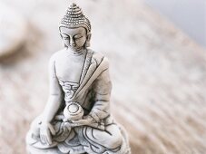 Close-up of small Buddha statue on table