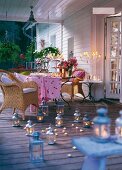 Laid table and armchairs on terrace decorated with candles
