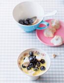 Zabaione with blue berries and almond biscuits in bowl