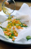 Fish in parchment with leeks and peppers on plate