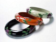 Three painted wooden bangles on white background