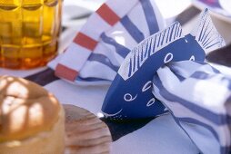 Fish shaped wood with blue and white striped napkin