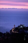 View of sea castle and yellow church at dusk, Eze, France