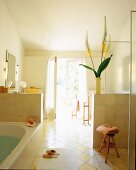 Interior of mediterranean style bathroom with semi-high walls separating bathing area