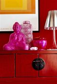 Asian style red sideboard with buddha statue, vases and lamp