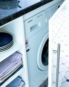 Close-up of white washing machine integrated in kitchen