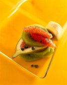 Close-up of fruit salad with grapefruit, orange, kiwi, figs and pistachios