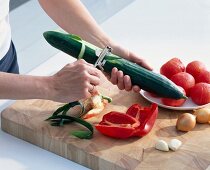 Peeling vegetables on chopping board - Preparation of gazpacho