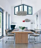 View of dining room with set table and modern chandelier