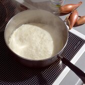 Cream reduced in saucepan on induction cooker
