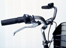 Close-up of adjustable handlebars and black basket on touring bike 