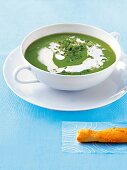 Pea soup with chives, horseradish cream and a puff pastry stick
