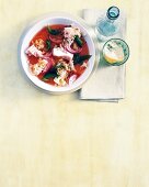 Fischsuppe mit Sauerkraut, Zwiebeln und Paprika, daneben ein Glas Wasser
