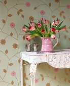 Table with tulip vase against floral wallpaper