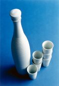 White porcelain bottle and stacks of porcelain cups