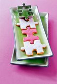 Puzzle shaped cookies and cutter on green ceramic plate