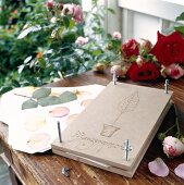 Plant press with rose petals and flowers on table