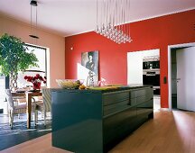 schwarzer freistehender Küchenblock in Küche mit roter Wand und Eßplatz