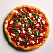 Pizza topped with green chillies and sage on white background