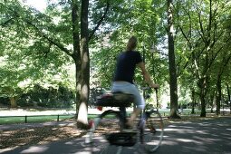 Rear view of woman cycling in park