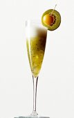 Longdrink "Kiwi Royal" m. Champagner und Bananensirup, garniert mit Kiwi