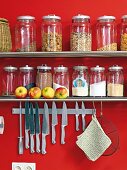 Knife hanging from magnetic bar under shelf with preserving jars