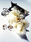 Clutch with bracelet, beads and fabric flowers on white background