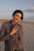 Janine Frau hört am Strand Musik