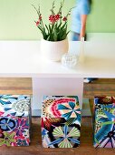Multi-coloured cube seats with floral pattern against white table