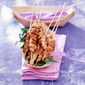 Skewers in plywood bowl on purple background