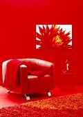 Trendfarbe Rot im Wohnbereich: roter Ledersessel vor einer roten Wand.